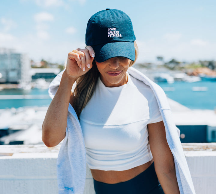 Katie wearing a Love Sweat Fitness baseball cap with logo printed on it