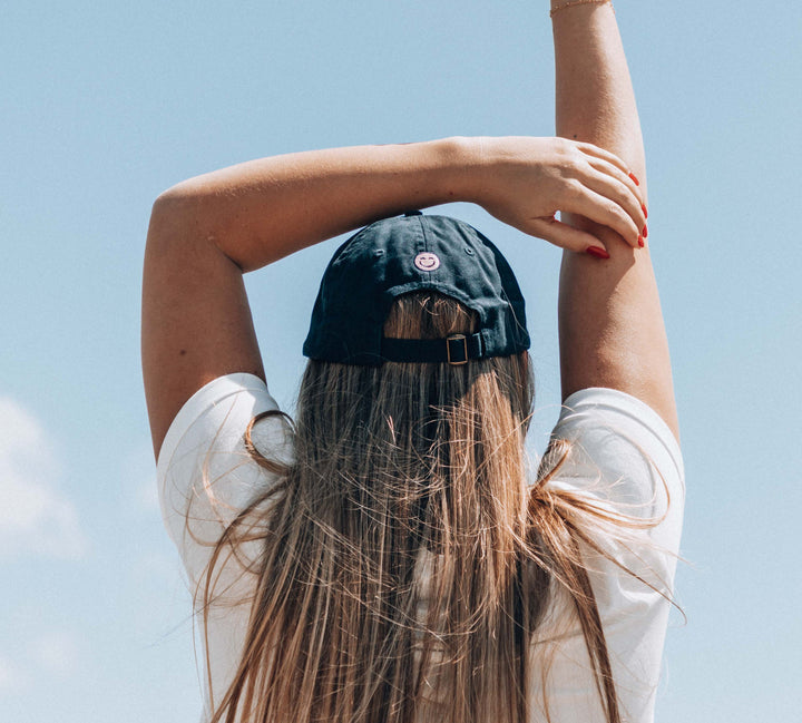 Katie wearing a Love Sweat Fitness baseball cap with logo printed on it