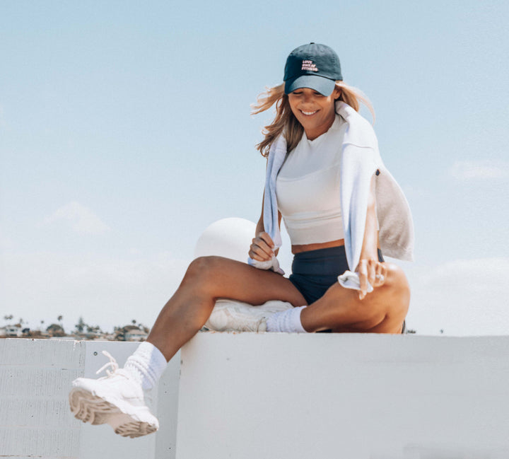 Katie wearing a Love Sweat Fitness baseball cap with logo printed on it