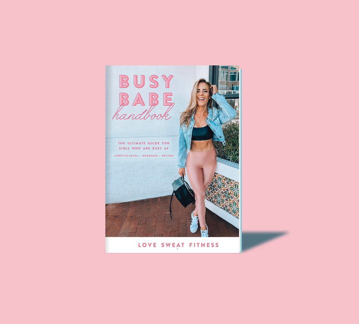 The image shows the cover of an e-book titled 'Busy Babe Handbook' by Love Sweat Fitness. The cover features a woman smiling and posing with a fitness-themed backdrop.