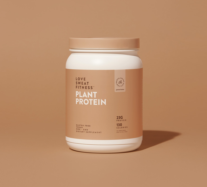 A container of Love Sweat Fitness Plant Protein powder with a label showing the brand name and 'PLANT PROTEIN' text, with a creamy beige background.