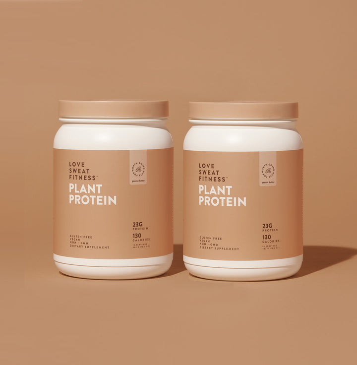 Two containers of Love Sweats Fitness Plant Protein powder with the label showing '23g Protein' and other nutritional information on a beige background.