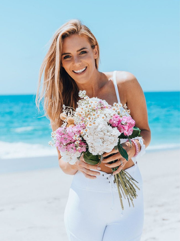 Katie from LSF with flowers on the beach